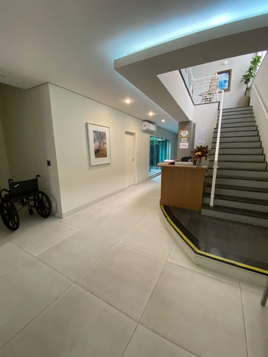 Entrada da Clínica Médica Atos, com cadeira de rodas à disposição.